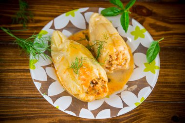 Tahta bir masada et ve kavrulmuş biber sosuyla doldurulmuş pilav.