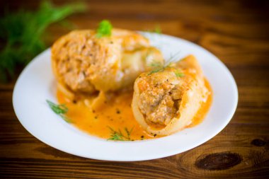 Tahta bir masada et ve kavrulmuş biber sosuyla doldurulmuş pilav.