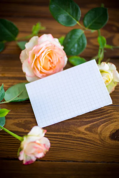 粉色美丽的夏季玫瑰 有空白的信笺头 放在木制桌子上 — 图库照片