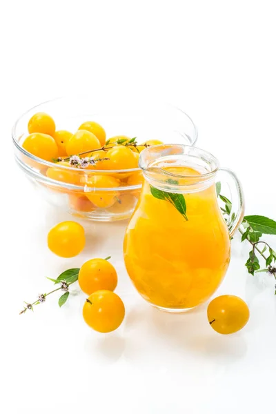用成熟的黄樱桃李子在白盘上的玻璃瓶里煮出甜甜的椰子酱 — 图库照片