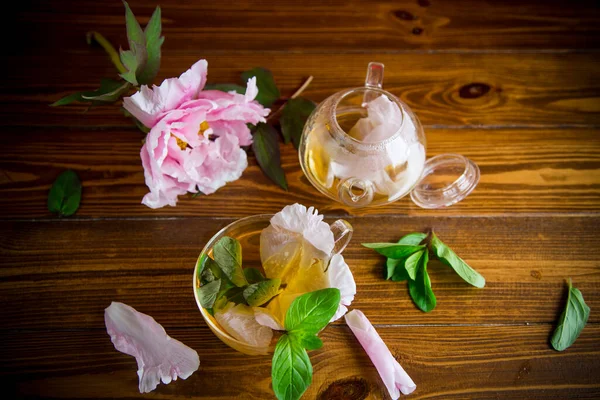 Letnia Herbata Kwiatowa Płatków Róż Szklanym Czajniku Czerwonym Tle — Zdjęcie stockowe