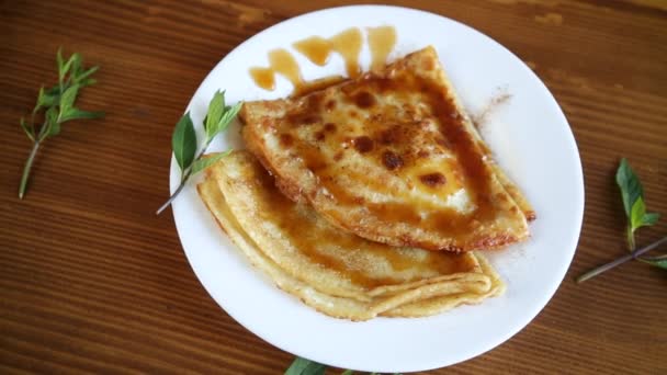 Fried thin pancakes with sweet caramel in a plate — Stock Video