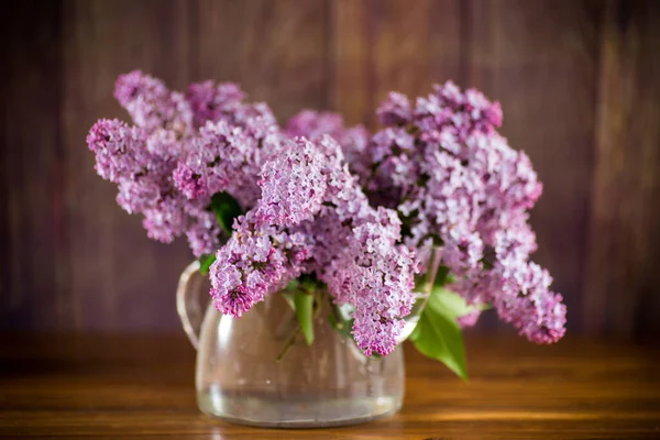 식탁에는 아름다운 라일락 꽃이 피어 있는 꽃다발 — 스톡 사진