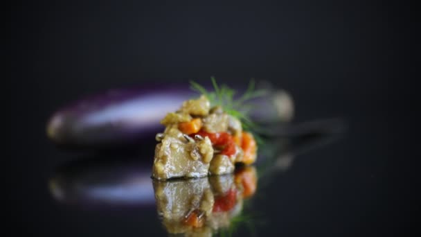 Cooked summer eggplant caviar with vegetables on black background — Stock Video
