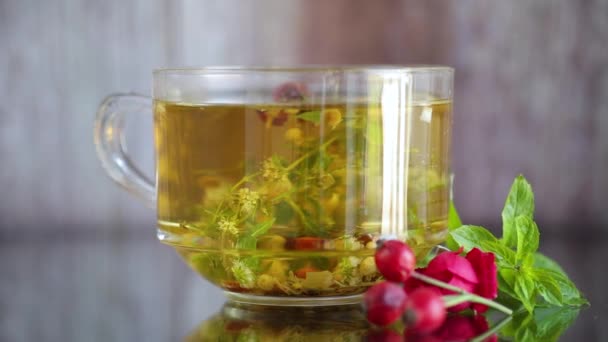 Натуральный горячий чай из различных летних трав в стакане — стоковое видео