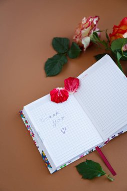 Çiçekler, köpüklü kahve ve boş sayfalarla dolu rahat bir masa..