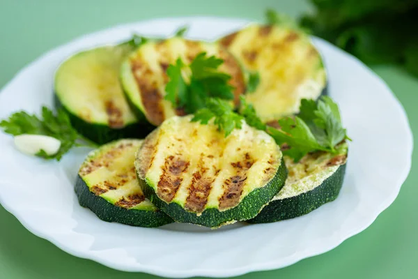 Yeşil arka planda kızarmış kabak dilimleri..