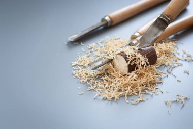 Gri arka planda ahşap talaşı olan marangozluk araçları.