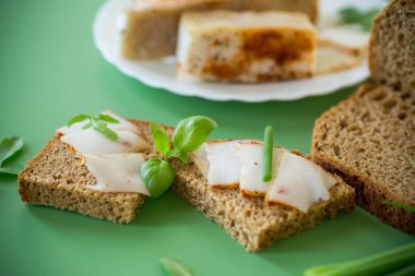 Yeşil zemin üzerinde domuz yağı ve yeşillik bulunan geleneksel Ukrayna yemeği.