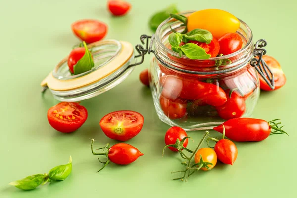 Kavanozdan dökülen taze kırmızı ve sarı domatesler..