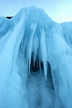 buz mağarasından görünümü. sarkıt gibi dondurulmuş, kristal berraklığında su damlaları tavandan asmak. yükselen güneş lekeli buz. kısmen renkli fotoğraf. merkezi bir nesneye odaklanın. Ekstra sığ alan derinliği.