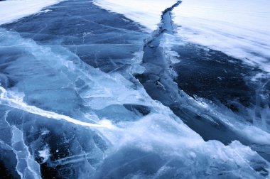 Ice hummocks on the northern shore of Olkhon Island on Lake Baikal. Fresh crack broke the thick ice. Fresh clean water rises from the depths and freeze in the cold. Ice Storm. Photo partially tinted clipart