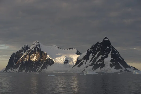 Widok na góry ze statku o zachodzie słońca na Antarktydzie — Zdjęcie stockowe