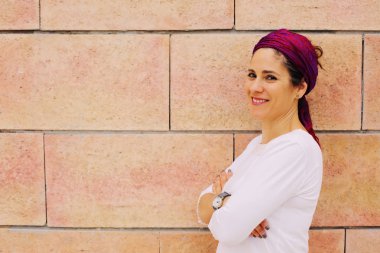 40 yaşında bir kadın tuğla duvar arka plan üzerinde gülümseyen portresi