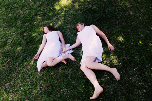 High angle view of mother and daughter lying on grass in park