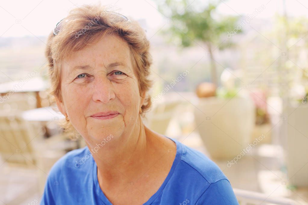 portrait of senior woman sitting in outdoor cafe 