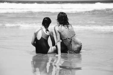 Anne ve kızı eğleniyor birlikte sahilde günbatımında zaman geçirmek için