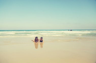 Anne ve kızı eğleniyor birlikte sahilde günbatımında zaman geçirmek için