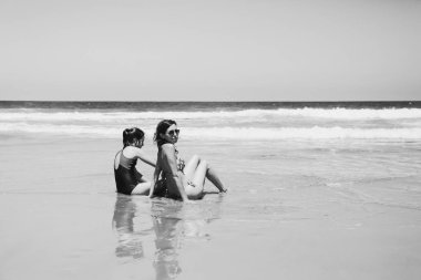 Anne ve kızı eğleniyor birlikte sahilde günbatımında zaman geçirmek için