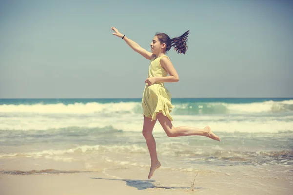 12岁女孩少女少女穿着黄色礼服走在海边 — 图库照片