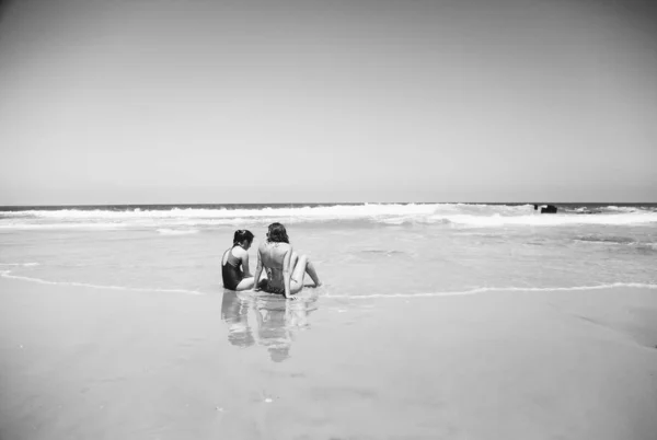 母女俩在日落时在海滩上度过时光很开心 — 图库照片