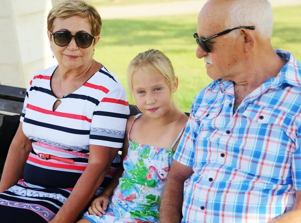 Grandparents And Granddaughter Enjoying Day In Park