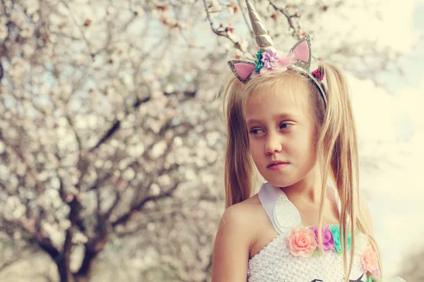 Outdoor portrait of girl in a unicorn costume. Spring is around, — Stock Photo, Image