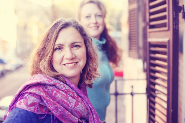 Schöne reife Frau, die auf dem Balkon steht und nach oben schaut — Stockfoto