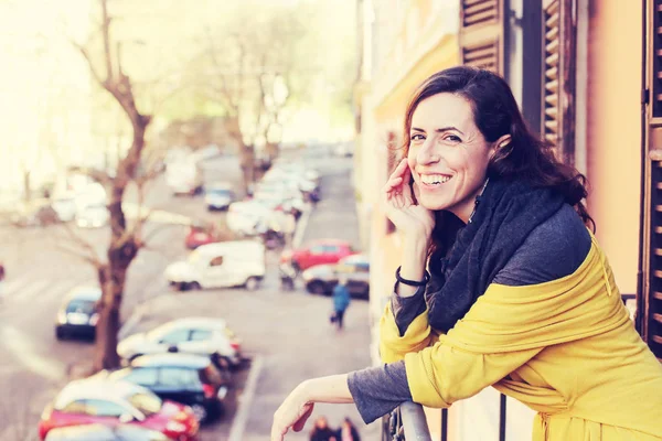 Schöne reife Frau, die auf dem Balkon steht und nach oben schaut — Stockfoto