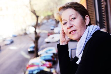 caddeye bakıyor Balkonda duran güzel Olgun kadın