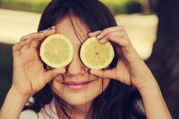 快乐的12岁小女孩笑着拿着柠檬片 — 图库照片