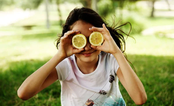 快乐的12岁小女孩笑着拿着柠檬片 — 图库照片