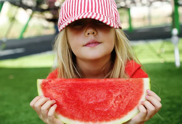 Porträt des niedlichen kleinen 8-jährigen Mädchens, das Wassermelone auf th isst — Stockfoto