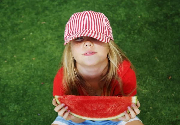 Retrato de bonito pouco 8 anos de idade menina comendo melancia no th — Fotografia de Stock