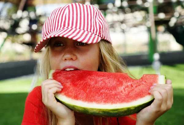 Portrait of cute little 8 years old girl eating watermelon on th — Stock Photo, Image