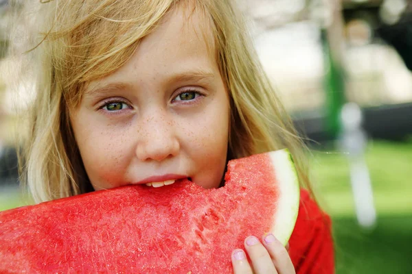 Porträt des niedlichen kleinen 8-jährigen Mädchens, das Wassermelone auf th isst — Stockfoto