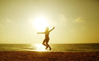 Mutlu küçük kız gün batımında sahilde koşuyor - tatil tatili