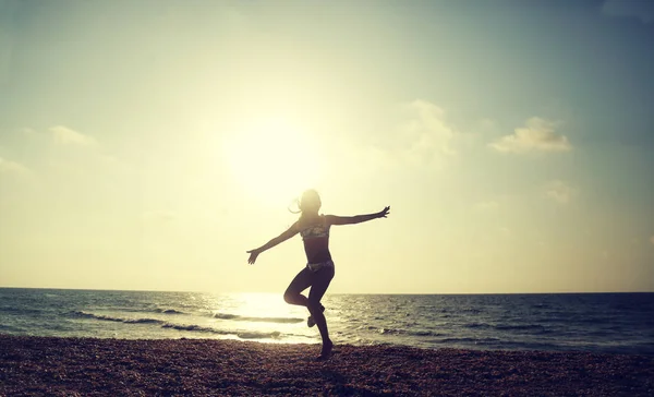 Gelukkig meisje loopt op het strand bij zonsondergang - vakantie vaca — Stockfoto