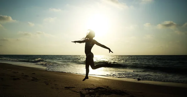 Menina feliz correndo na praia ao pôr-do-sol - vaca férias — Fotografia de Stock