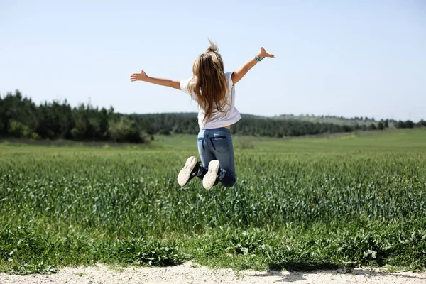 9歳の少女が花畑を歩いている — ストック写真