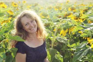 Mutlu olgun bir kadının portresi Ayçiçeği tarlasında özgürlüğün tadını çıkarıyor