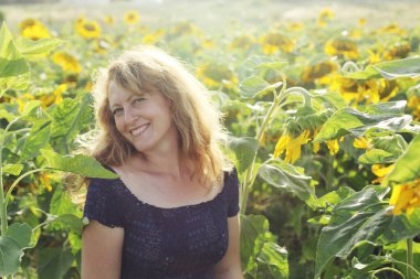 Mutlu olgun bir kadının portresi Ayçiçeği tarlasında özgürlüğün tadını çıkarıyor