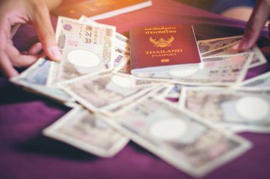 Tay kişisel pasaport turist için Japonya'ya gidin. Japon para birimi 10000 Yen banknot seyahat ve Japon ekonomisi kavramı için hazırlayın. Tayland Bahtı yen değişimi.