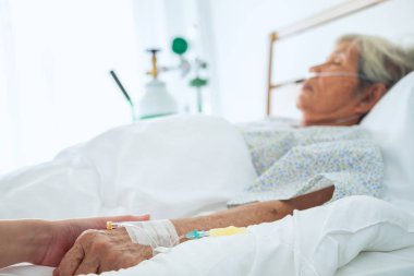 Tıp doktoru koşullarının üst düzey hastanın el ve onu klinikte, üst düzey kadına dokunmak adamın elini teselli için yaşlı kavramı iyi bak