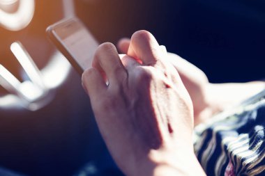 Adamın elleri bir arabanın içinden akıllı telefon tutarak. Tonda etkisi