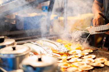 Barbekü ızgara tarak yanıyor. Tay deniz ürünleri, tereyağı ve peynir ile tarak ızgara. ızgara tarak itibariyle yerel sokak gece market pattaya city, Tayland satış.