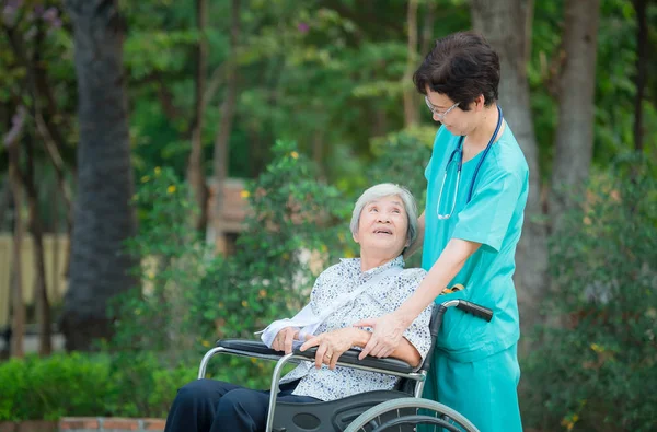 Lächelnde Pflegekraft Altenpfleger kümmern sich um einen älteren Patienten auf whe — Stockfoto