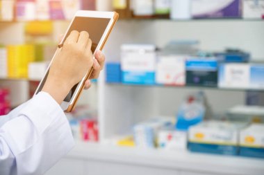 Eczanede tablet bilgisayarla çalışan eczacı