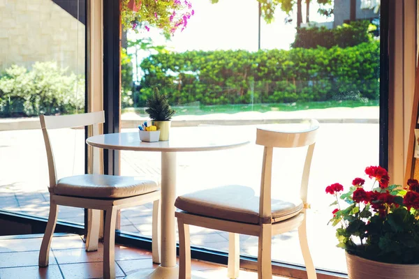 Una mesa en un café con maceta. Dos sillas vacías esperando — Foto de Stock