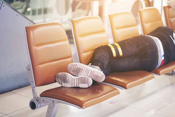 Pasażer spać na ławce w terminalu lotniska czeka na jego f — Zdjęcie stockowe